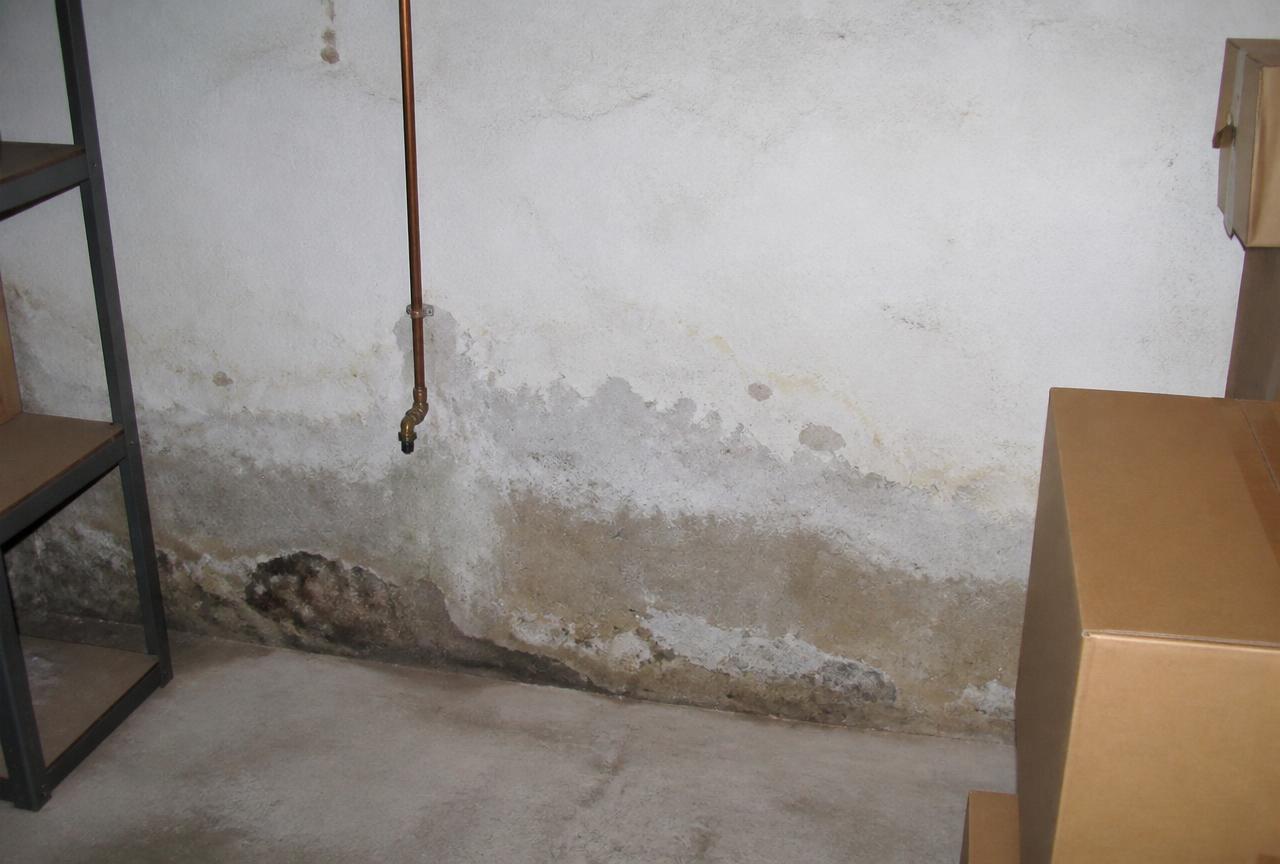 Mur de sous-sol humide près d'une arrivée d'eau en cuivre dans une maison d'Yerres